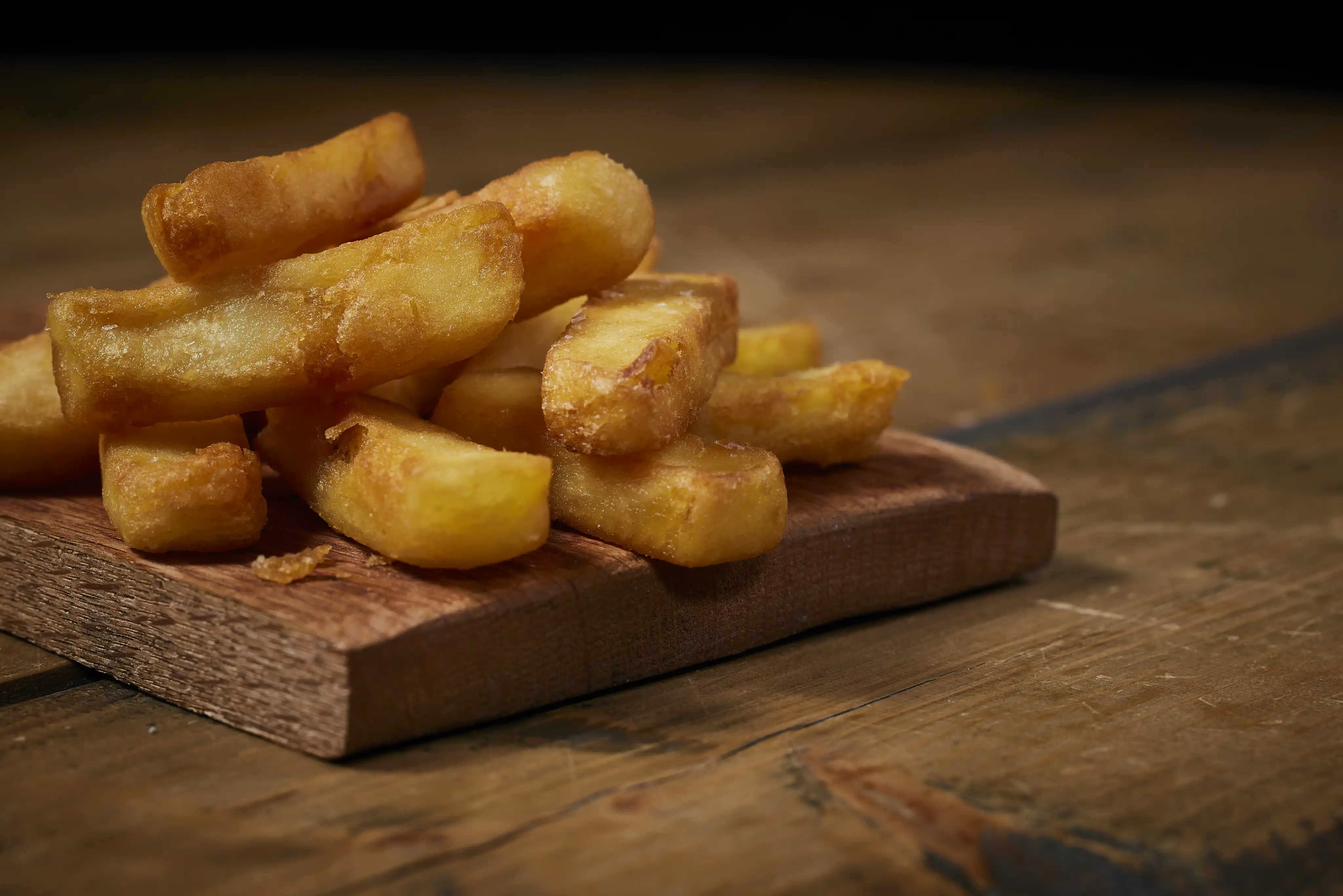 Picture of McCain triple cooked chips on a wooden board 